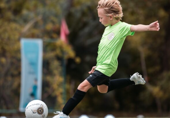 A child strikes a football at Kuramathi Maldives