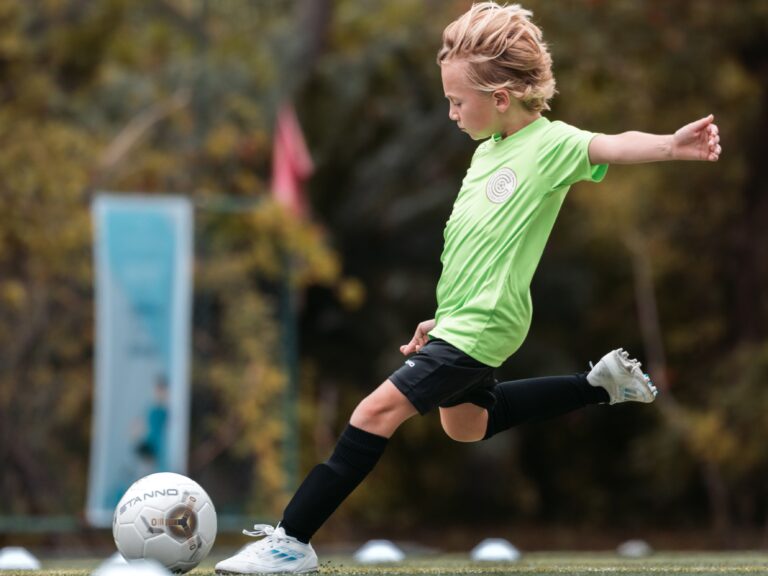 A child strikes a football at Kuramathi Maldives