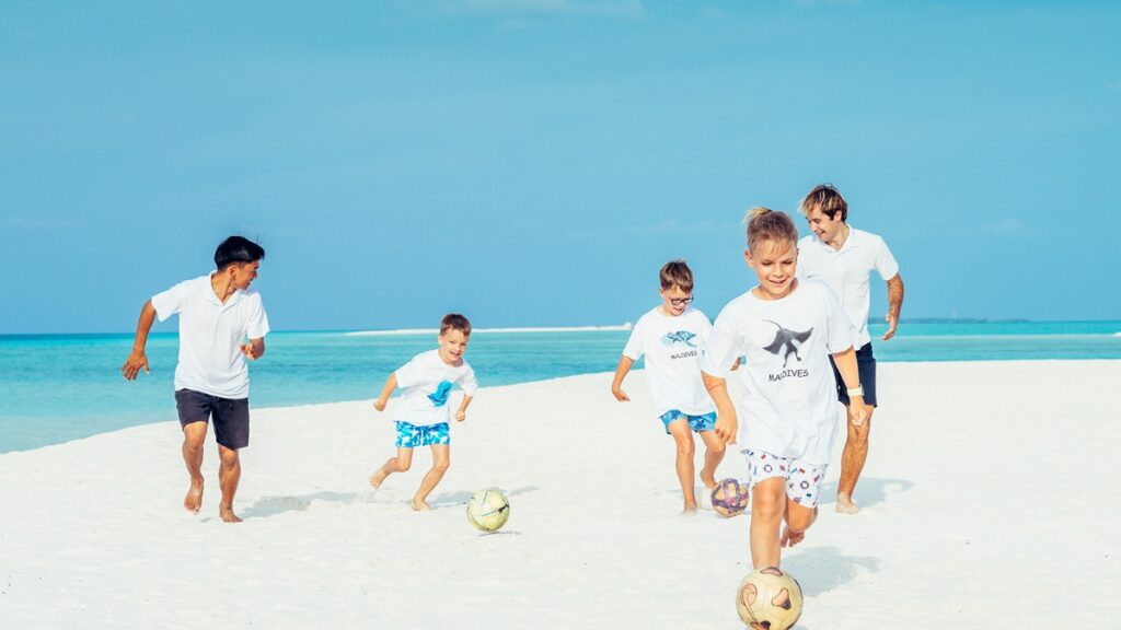 Kids play football on a Maldives beach