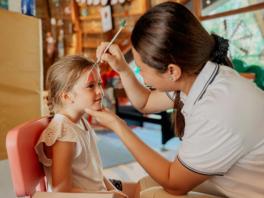 A little girl gets her face painted at Niva Kuramathi kids' club